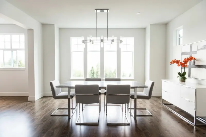 A serene dining room virtually staged in a slick Modern style generated with AInteriors interior design app, compared to the empty original.